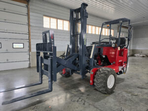 Moffett M55P Moffett M55 truck-mounted forklift in a warehouse setting, showcasing its robust design and operational features, emphasizing material handling capabilities.